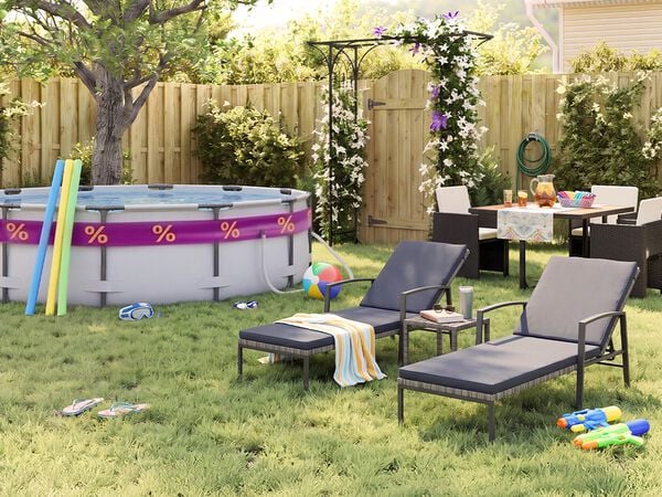 Jardin arri&egrave;re ensoleill&eacute; avec piscine hors sol, frites de piscine, lunettes de natation, ballon de plage et tongs pos&eacute;s dans l&rsquo;herbe. Deux transats noirs en m&eacute;tal avec coussins gris sont install&eacute;s pr&egrave;s d&rsquo;une petite table d&rsquo;appoint, tandis qu&rsquo;un ensemble repas de jardin avec fauteuils tress&eacute;s fonc&eacute;s se trouve pr&egrave;s d&rsquo;une pergola fleurie, d&rsquo;une cl&ocirc;ture en bois et de plantes verdoyantes.