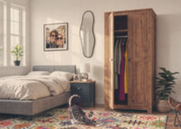 Chat qui s&rsquo;&eacute;tire sur le sol d&rsquo;une chambre avec une garde-robe en bois et des meubles de rangement.